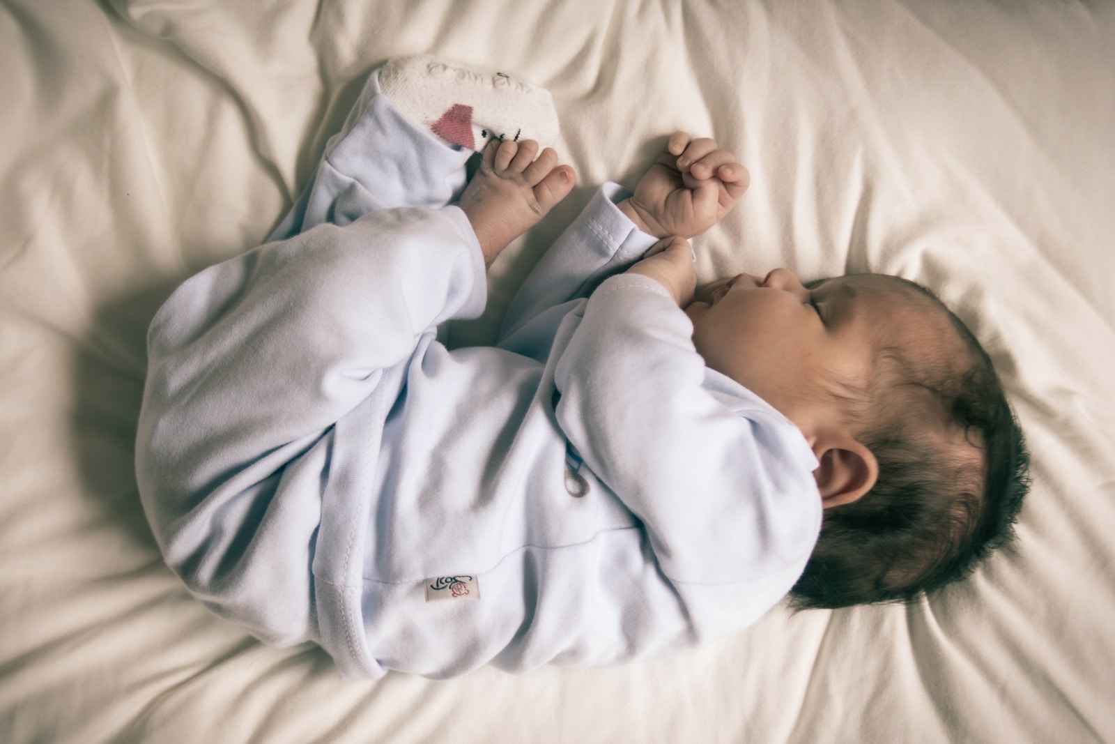 when can babies sleep with a blanket